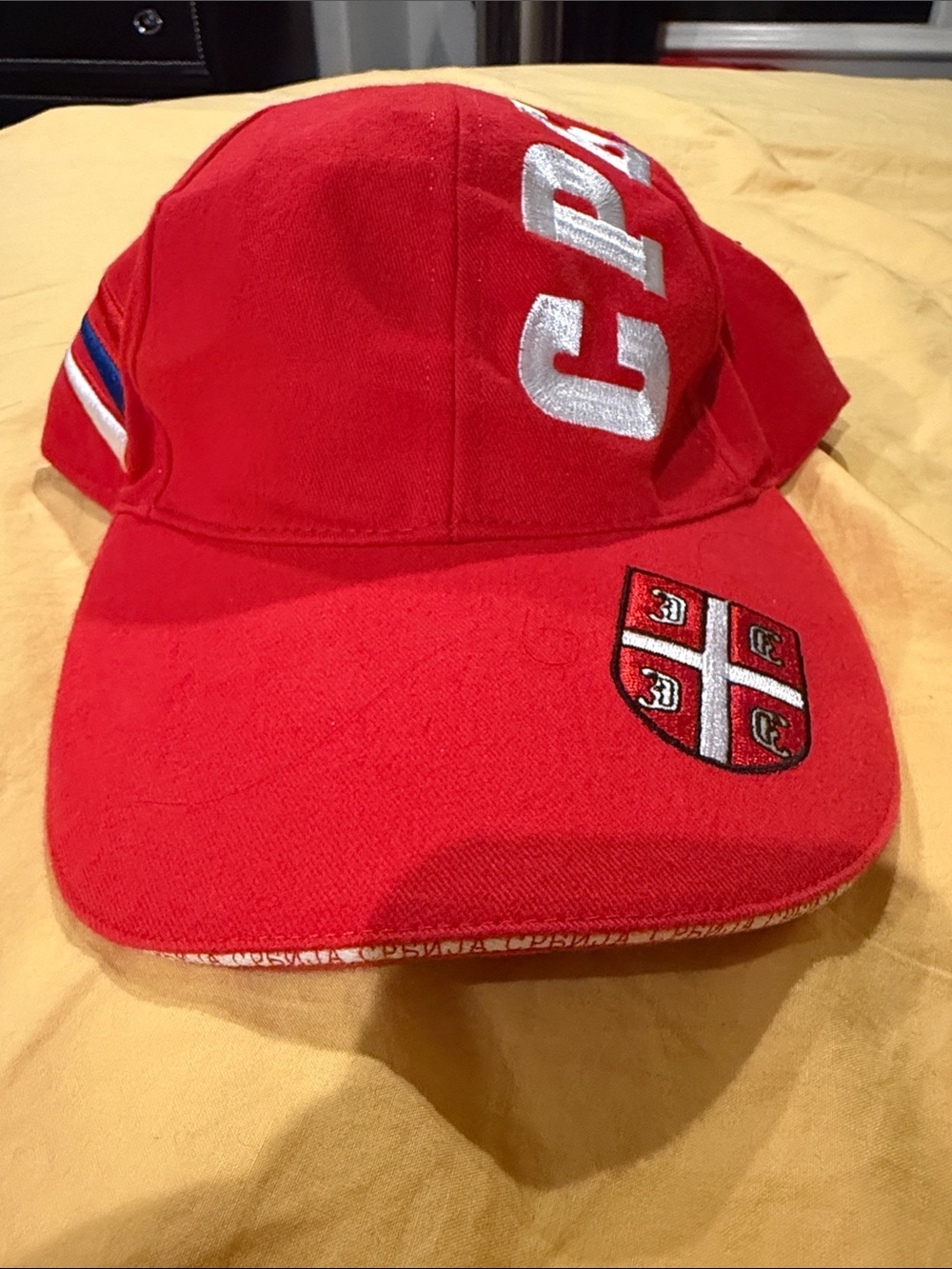 red cap with the Serbian coat of arms